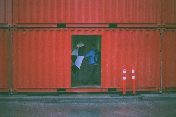 man holding umbrella inside the intermodal container