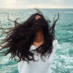 woman standing near body of water during daytime