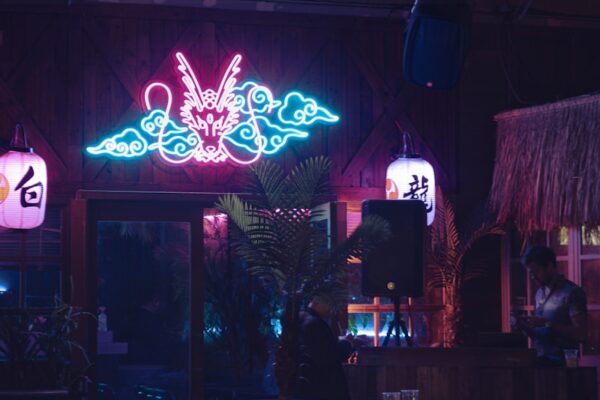 A restaurant with a neon sign above the tables