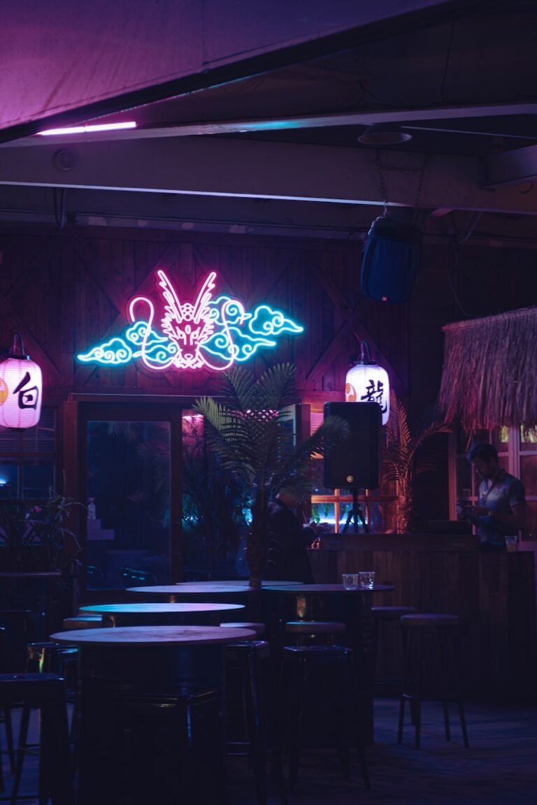 A restaurant with a neon sign above the tables