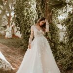 woman in white wedding dress standing near green trees during daytime